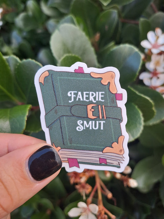 Faerie Smut book sticker held by Steph is glittery.