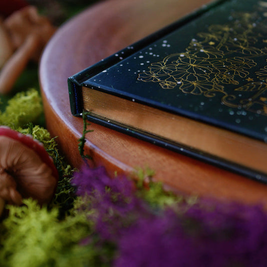Dark green journal with intricate gold patterns, showing gold edges.