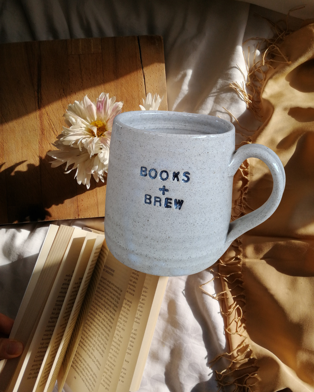 Books + Brew Mug with indented text shown on a themed flatlay background.