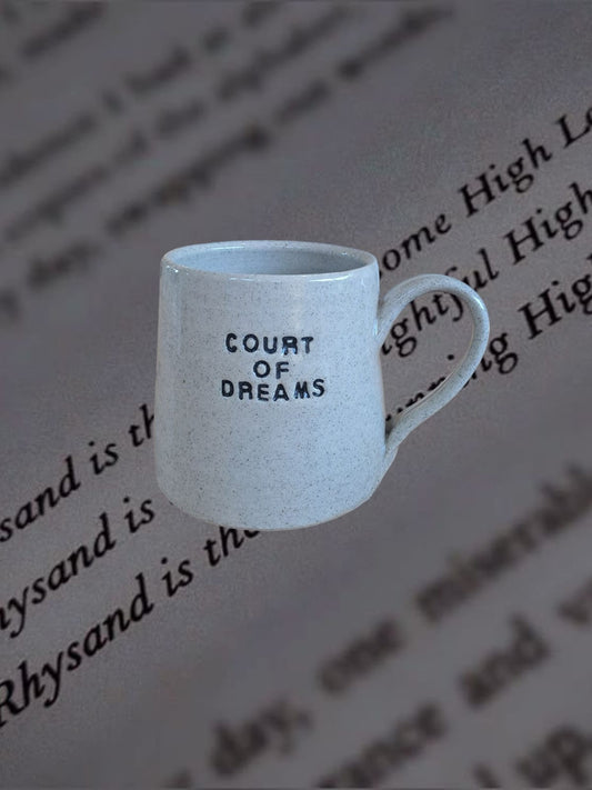 Court of Dreams Mug with indented text shown on an open book background.