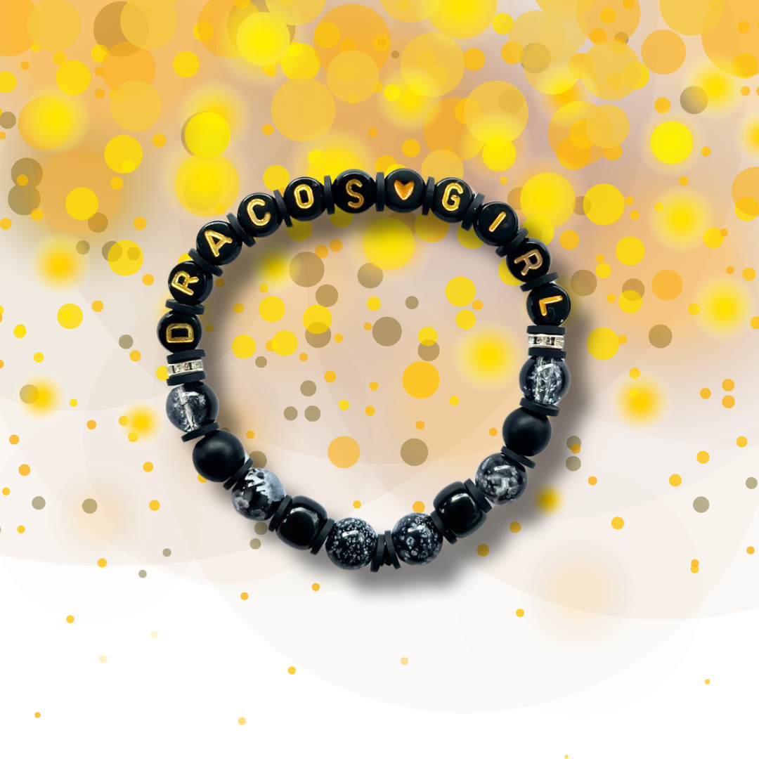 Black beaded bracelet with the words Dracos Girl, on a golden background.