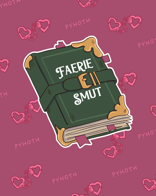 Sticker is a green book with clasp and white text: Faerie Smut, shown on a pink background with heart cufflinks.