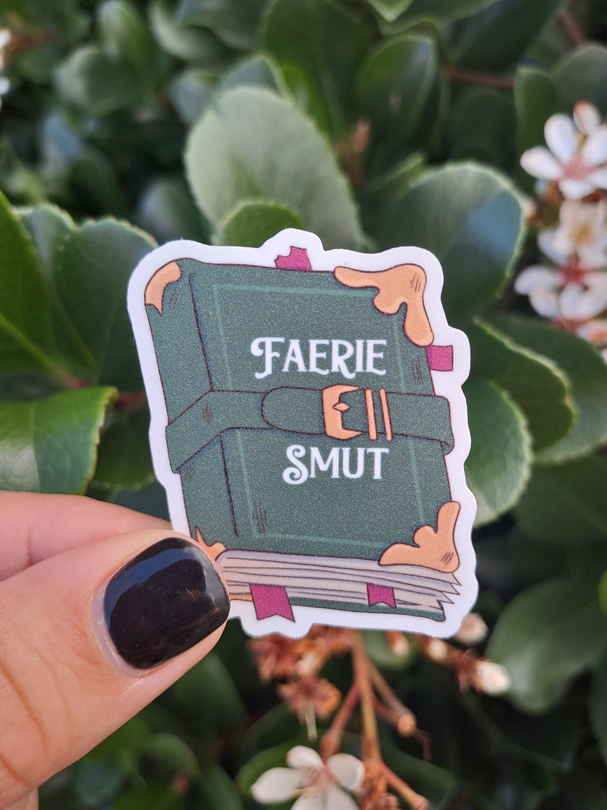 Faerie Smut book sticker held by Steph is glittery.