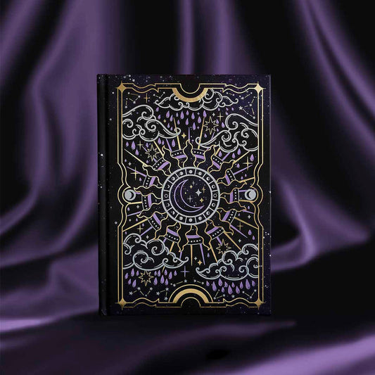 Black journal with intricate gold and purple patterns, shown on a purple satin background.