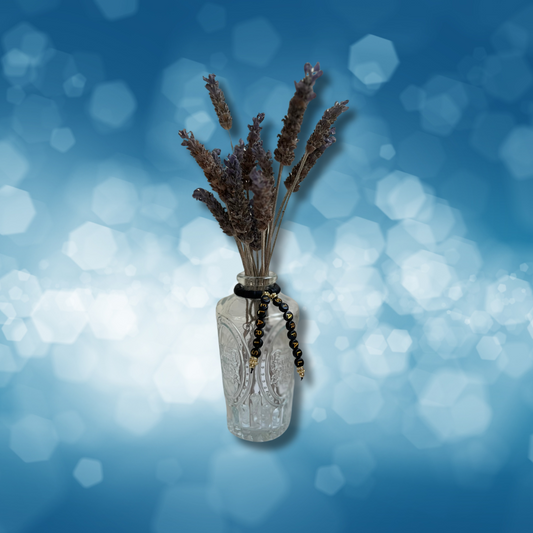 Glass vase with beads that say Starfall and Velaris. Vase with lavender in it, shown on a blue background.