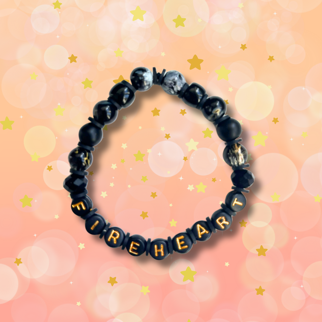 Black beaded bracelet with the word Abraxos, on a peach coloured background with stars.