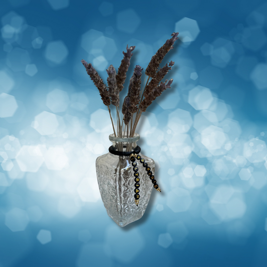 Glass vase with beads that say Valkyrie and Illyrian. Vase with lavender in it, shown on a blue background.
