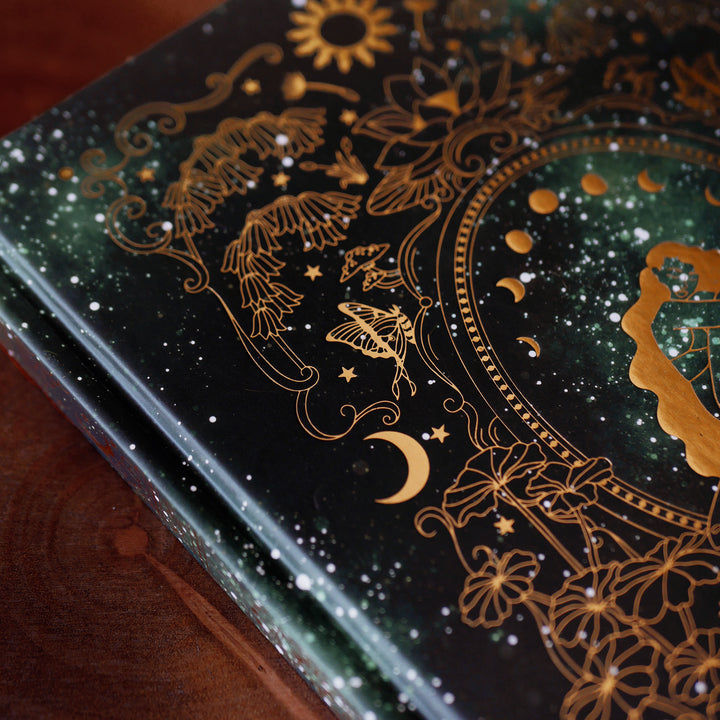 Dark green journal with intricate gold patterns, close up detail.